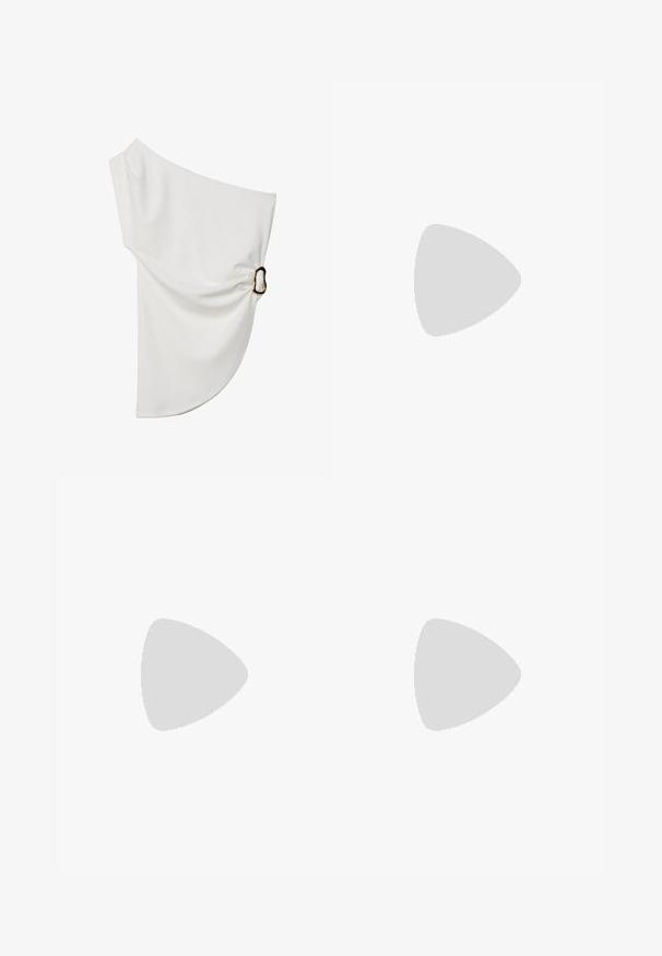 Off-the-shoulder vit blus i mjukt tyg, med en samlad detalj och en metallring som accent på ena sidan.; Denim joggerbyxor med bred elastisk midja, två sidofickor och ribbat avslut; mörkblå färg med kontrasterande sömmar.; Vit platt sko med spetsig tå, dekorerad med silvernitar, har ett spänne över fotryggen och en ljusbrun sula.; En stapel med två ringar; den översta är bärnstenfärgad med virvlar, och den nedersta är ljusbeige; båda är släta och glansiga i resin.