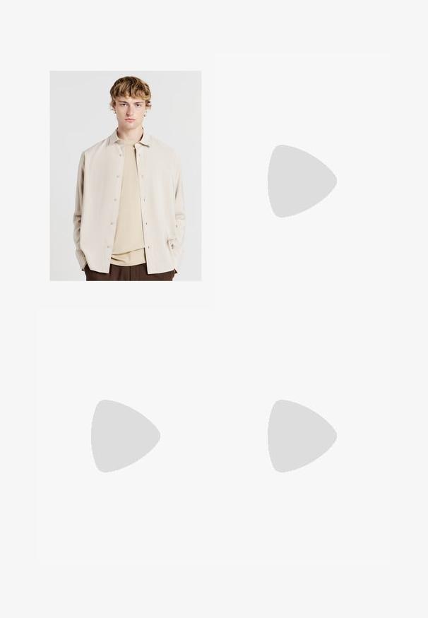 Calliope Hemd - corda; Braune Plisseehosen mit weitem Bein, ausgestattet mit einem Knopfverschluss und seitlichen Taschen, aus strukturiertem Stoff, der sich gut für Freizeitkleidung eignet.; Schwarze Nike Air Max Sneaker mit einem strukturierten Leder-Obermaterial, Gummisohle und auffälligem Schnürsystem, das ein schlankes, modernes Design präsentiert.; Schildpatt-Sonnenbrille mit grünen Gläsern, in einer achteckigen Form und schlanken, gebogenen Bügeln. Das Material hat eine glänzende Oberfläche.