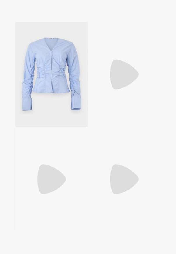 Ανοιχτό μπλε μπλούζα με μακρύ μανίκι, V-λαιμόκοψη, τσαλακωμένες πλευρές και εφαρμοστό μέση. Διαθέτει φαρδιές, δομημένες μανσέτες και μαλακό, ελαφρύ ύφασμα.; Ναυτικό μπλε παντελόνια με φαρδιά πόδια από μαλακό ύφασμα, με εμπρόσθιες πτυχώσεις, λεία υφή και ίσια εφαρμογή χωρίς ορατές τσέπες.; Ναυτικό μπλε πλατφόρμα με διασταυρωμένες λωρίδες, σαγρέ πλατφόρμα από φυσικές ίνες και χρυσό μεταλλικό στοιχείο στη βάση.; Μαύρη τσάντα χειρός με δομημένο σχήμα, λεία υφή και μεταλλικό κούμπωμα. Συνδυασμένη με φαρδιά μαύρα παντελόνια και σανδάλια ανοιχτής μύτης πάνω σε ξύλινο πάτωμα.