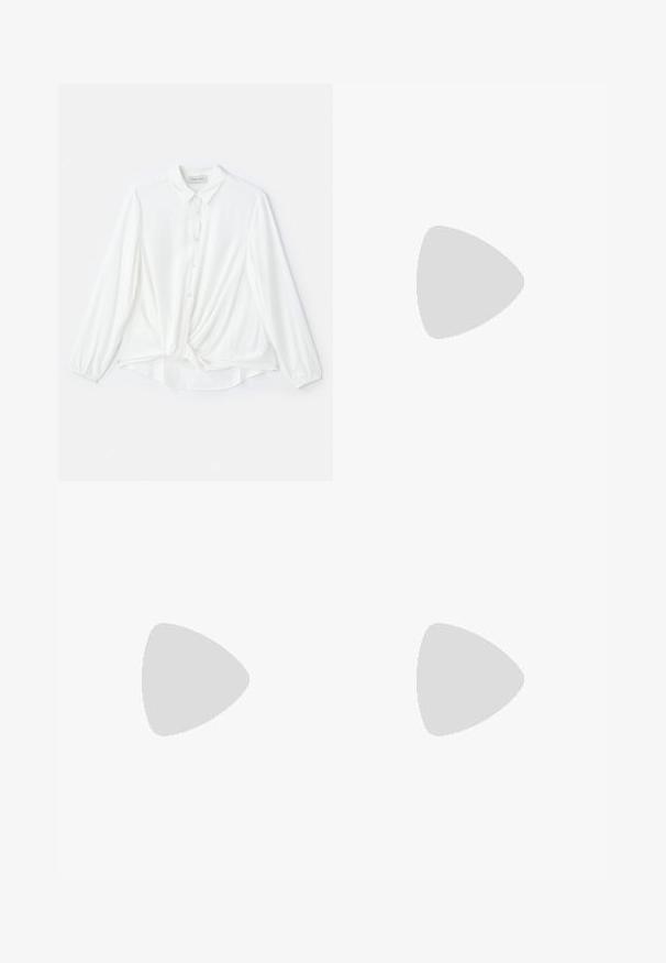 Blusa bianca a maniche lunghe con collo a punta, chiusura con bottoni e dettaglio annodato in vita. Realizzata in tessuto leggero e morbido.; Jeans in denim a gamba larga di blu medio, con vita alta, chiusura con bottone e dettagli delle cuciture verticali a contrasto lungo la parte anteriore.; Décolleté in vernice nera con punta affusolata e tacco in geometria cubica. Presentano un design elegante e minimalista, con una texture liscia.; Borsa a secchiello metallica argento con finitura testurizzata, decorata con un manico rotondo argento e chiusura a cordoncino, tenuta contro dei jeans azzurri.