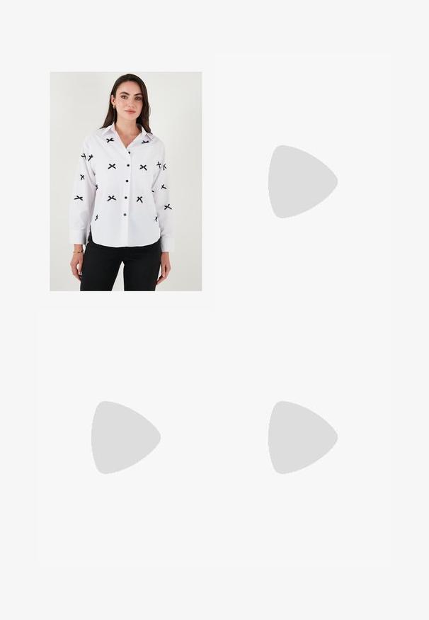 White button-up shirt with black cross embroidery, long sleeves, buttoned cuffs, and black buttons. Smooth texture, classic collar design.; Cream-colored satin wide-leg pants with black embroidered geometric patterns along the hem. Features a smooth texture and tailored silhouette.; Beige leather block-heel pump with a pointed toe, black trim along the opening, and a thin adjustable slingback strap with gold hardware.; Cream leather handbag with a crescent shape, gold hardware, black accents, and a removable strap. Features a chain detail and tag.