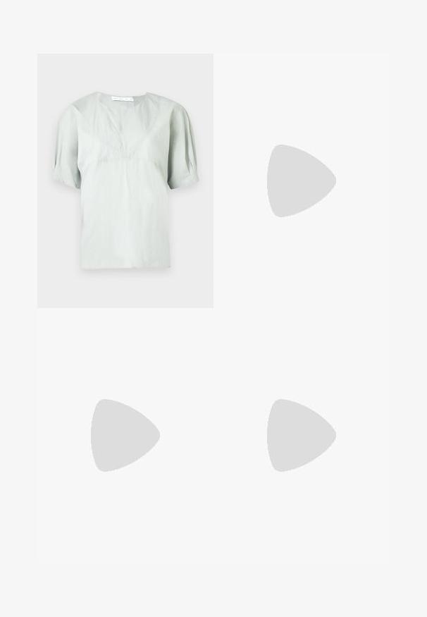 Világosszürke rövid ujjú felső kerek nyakkivágással és finom textúrával. Laza szabású, enyhén puffadt ujjakkal a kényelmes mozgásért.; Fekete midi szoknya gyűrött textúrával, egyenes szabással és oldalsó hasítékkal. Az anyag könnyűnek tűnik. A szoknya alja kissé kerekített.; Fekete bőr bokapucs blokksarkúval, kontrasztos varrással és ívelt orr kialakítással. Simább textúra, elegáns vonalvezetés.; Barna bőrtáska ívelt formával, dupla aranyszínű fémhardverrel, két elülső zsebbel és széles pánttal. Simán textúra elegáns kivitelben.