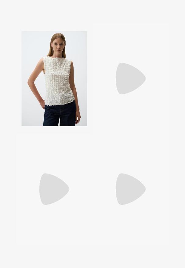 Weißes ärmelloses Top mit strukturiertem, gerüschtem Muster. Verfügt über einen hohen Kragen und einen asymmetrischen Saum, ergänzt durch eine dunkle Denim-Hose.; Beige Glockenhosen mit hohem Bund, aus Baumwollstoff. Verfügt über Vorder- und Hintertaschen, Gürtelschlaufen und einen einzelnen silbernen Knopf.; Schwarze Lederloafers mit flachem Absatz, die auf der Vorderseite ein dekoratives goldfarbenes Hardware-Detail und eine glatte Textur aufweisen.; Schwarze Handtasche mit strukturierten Oberflächen, doppelten Obergriffen und verstellbarem Schultergurt. Mit goldfarbener Hardware und Seitentaschen.