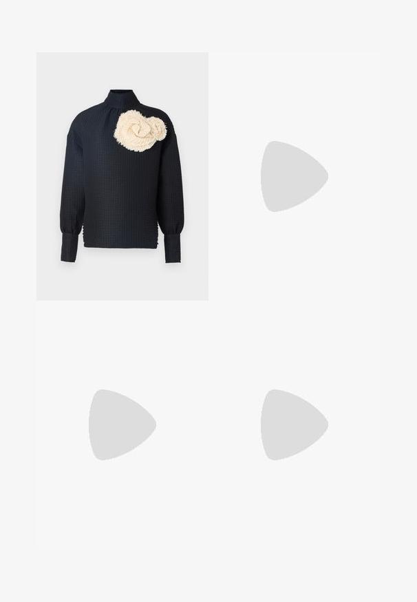 Maglietta nera a maniche lunghe con superficie texture, caratterizzata da una rosa testurizzata di colore crema sulla spalla sinistra. Collo alto, maniche aderenti.; Jeans neri a gamba larga realizzati in denim, con design a cinque tasche, chiusura con bottone e dettagli in metallo. Tessuto testurizzato con una finitura liscia.; Stivale alla caviglia in pelle nera con punta affilata, tacco a stiletto sottile e tomaia aderente simile a una calza. Texture liscia con dettagli di cucitura minimi.; Orecchino a cerchio in oro con una piccola gemma decorativa. Indossato da un modello con capelli lisci, abbinato a una camicia bianca con colletto.