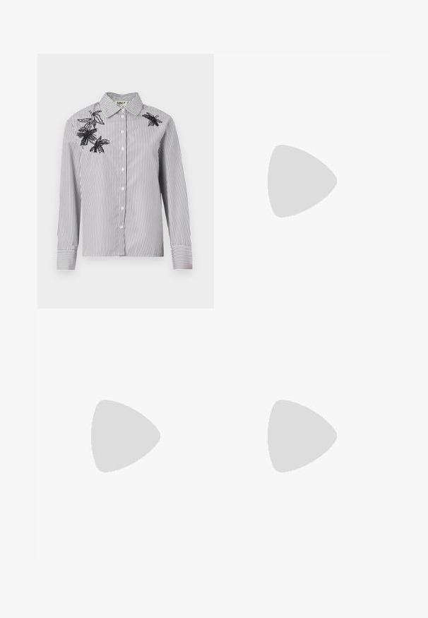 Camicia a righe bianca e nera con maniche lunghe, caratterizzata da ricami floreali neri sulla spalla sinistra e nella zona del petto.; Maglietta a maniche lunghe bianca a costine con collo a ruffle e orlo sfilacciato. Texture liscia, design aderente.; Pantaloni dritti blu navy realizzati in un tessuto morbido. Presentano una chiusura frontale con bottone e tasche laterali. Design semplice e moderno.; Scarpe slingback a punta in vernice beige lucida con tacco sottile e cinturino regolabile per una calzata sicura.