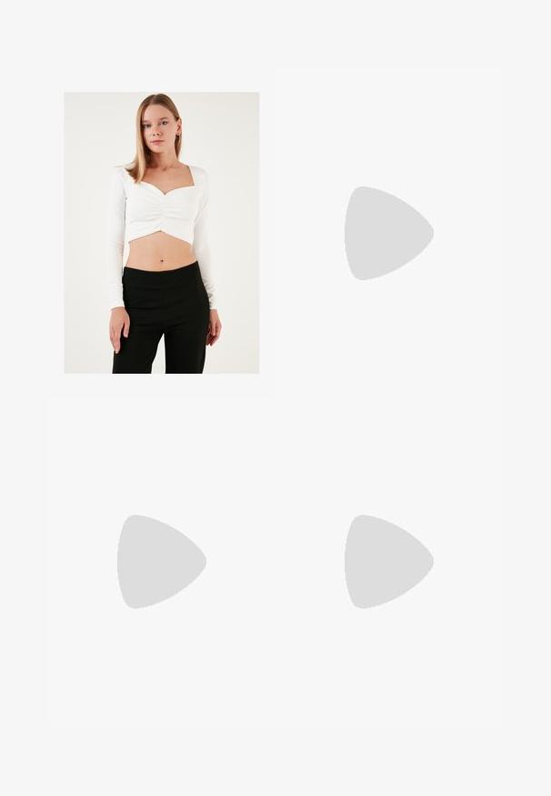 Fehér, hosszú ujjú crop top, négyzet alakú dekoltázzsal és ráncolt középrésszel, fekete, magas derekú nadrággal párosítva. Sima textúra.; Fekete, könnyű nadrág elasztikus derékkal és ráncolt bokákkal. Az anyag sima és laza, szűkített dizájnnal rendelkezik.; Fekete bőr platform cipők vaskos blokk sarkakkal, kerek orral és hagyományos fűzős kialakítással. Simára csiszolt felület és minimális részletezés jellemzi.; Fekete bőrtáska sima felszínnel, téglalap alakú, két hosszú füllel. Nincs látható fémkiegészítő vagy díszítés.