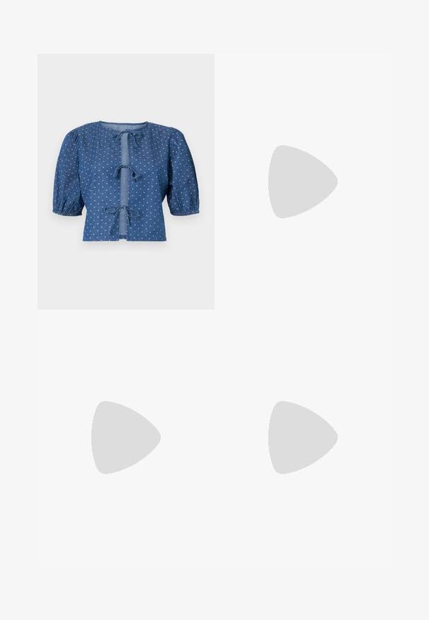 Jeansblus i mörkblått med puffärmar, försedd med knytband och ett subtilt mönster av små vita diamanter.; Vita högmidjade jeans med vida ben, tillverkade av denim; har fem fickor, kopparnitar och dragkedjeöppning.; Vit högklackad sandal med en kraftig klack, med ett remdesign och ankelband. Slät textur med en plattform framtill för ökad höjd.; Vit läderhandväska med en böjd form, justerbar rem och en liten spänndetalj. Modellen bär en åtsittande svart outfit.