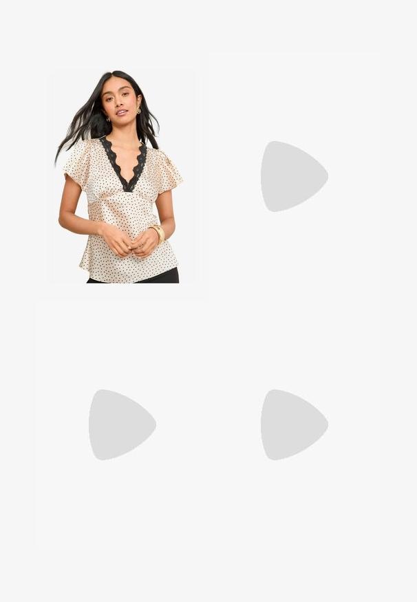 Blusa in satin a pois di colore crema con macchie nere. Caratterizzata da scollatura a V con bordo in pizzo e maniche volanti. Tessuto liscio.; Pantaloni a gamba larga in tessuto crema con una texture liscia, caratterizzati da un singolo bottone frontale, pieghe sottili e un design a vita alta.; Sandalo bianco con tacco alto, caratterizzato da un design a cinturini e un legaccio alla caviglia. Texture liscia con una piattaforma frontale per un'altezza aggiuntiva.; Borsa a mano bianca strutturata con manici corti e tracolla, dotata di dettagli in metallo dorato e materiale testurizzato, esposta su uno sfondo grigio.