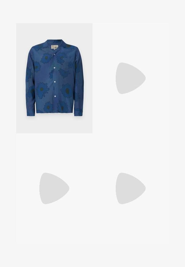 Σακάκι ναυτικού μπλε από ελαφρύ ύφασμα, με μεγάλα λουλούδια σε πιο σκούρες αποχρώσεις, γιακά, μπροστινή τσέπη και κουμπί κλεισίματος.; Λευκά, ραμμένα παντελόνια με επίπεδο μπροστινό μέρος, δύο πτυχές και γυρισμένα μανίκια. Φτιαγμένα από έναν λείο ύφασμα με κουμπί κλεισίματος στη μέση.; Μαύρα δερμάτινα loafers με κομψό σχέδιο, που διαθέτουν διακριτική ραφή και χαμηλό τακούνι, εμφανισμένα σε λευκό φόντο.; Πολύχρωμο κολιέ με χάντρες σε σκούρο μπλε, κόκκινο και κίτρινο, διακοσμημένο με ασημί λεπτομέρειες και ένα κρεμαστό γούρι.