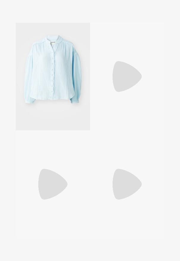 Light blue button-up shirt, textured fabric, round neckline, long puff sleeves, ruffled details along the button placket and cuffs.; High-waisted blue denim jeans with a wide-leg design, featuring a front pocket, brass button closure, and contrast stitching.; Light grey suede sneaker with white leather accents, three white stripes, and a brown rubber sole, featuring a padded collar for comfort.; Yellow transparent sunglasses with teal lenses, square shape, and a distinctive angled temple design featuring engraved detailing.