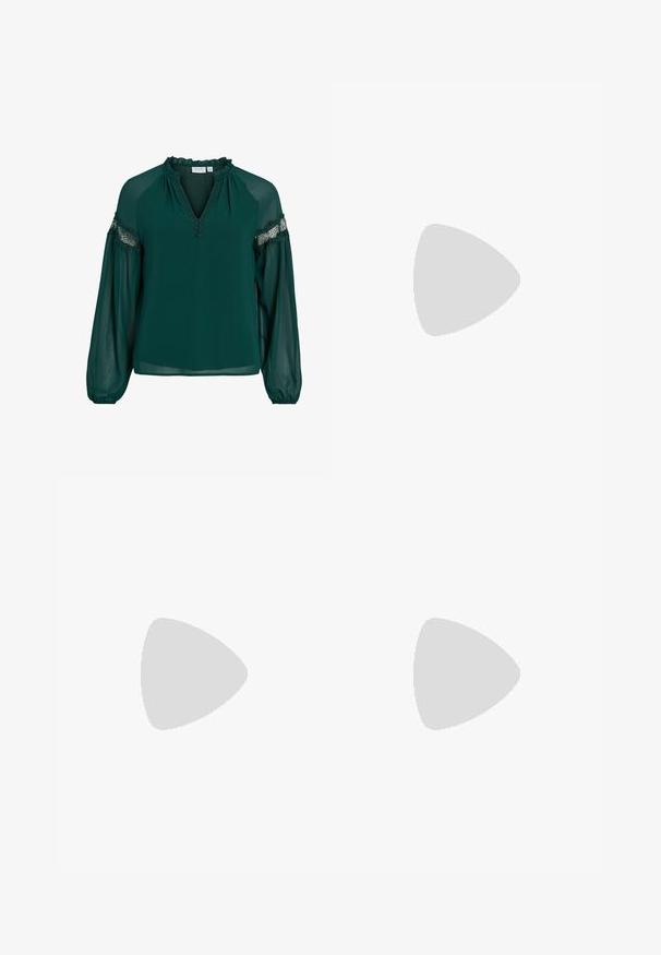 Ciemnozielona bluzka wykonana z lekkiego materiału, z falbaniastym dekoltem, koronkowymi akcentami na rękawach oraz luźnym krojem z marszczonymi mankietami.; Czarne jeansy o szerokich nogawkach wykonane z denimu, z wysokim stanem, pięcioma kieszeniami, przednim zapięciem na guziki oraz minimalistycznymi detalami szwów.; Bordowe baleriny z lakierowanej skóry z zaokrąglonym noskiem, małą kokardką z przodu oraz niską, czarną gumową podeszwą. Gładka tekstura.; Biała prostokątna kopertówka wykonana z błyszczącego materiału, z srebrnym łańcuszkiem. Modelka pozuje, prezentując torebkę na jednolitym tle.