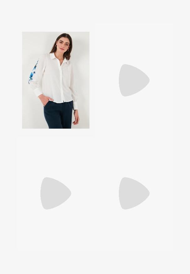 Chemise en lin blanc à boutons avec col, ornée de broderies florales bleues sur les manches, associée à un pantalon bleu foncé.; Pantalons palazzo en satin couleur crème avec des motifs géométriques noirs brodés le long de l'ourlet. Présente une texture lisse et une silhouette ajustée.; Escarpin en cuir beige à talon carré avec un bout pointu, bord noir le long de l'ouverture, et une fine bride arrière réglable avec des accessoires en or.; Sac à main en cuir crème avec une forme de croissant, quincaillerie dorée, accents noirs et une bandoulière amovible. Présente un détail en chaîne et une étiquette.