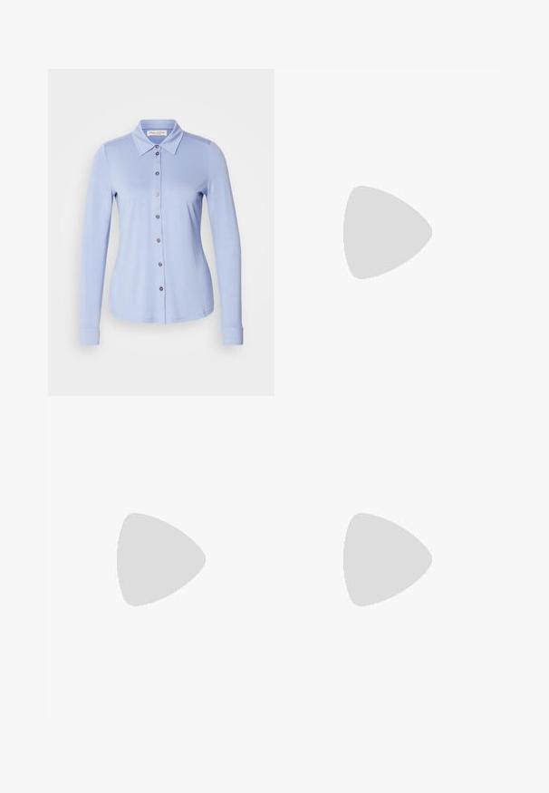 Lichtblauw blouse met lange mouwen en kraag, met een knoopsluiting aan de voorkant en knoopaccenten in een bijpassende kleur. Zachte, rekbare stof.; Zwarte wijde broek met hoge taille, knoopdetails op de tailleband en plooien aan de voorkant.; Zwarte gepatenteerde leren loafer met een vlakke zool, ronde teen en een decoratieve band met een gouden accen. Gladde, glanzende afwerking.; Zwarte handtas met gestructureerde vorm, gladde textuur en een metalen sluiting. Gecombineerd met brede zwarte broeken en sandalen met open teen op een houten vloer.