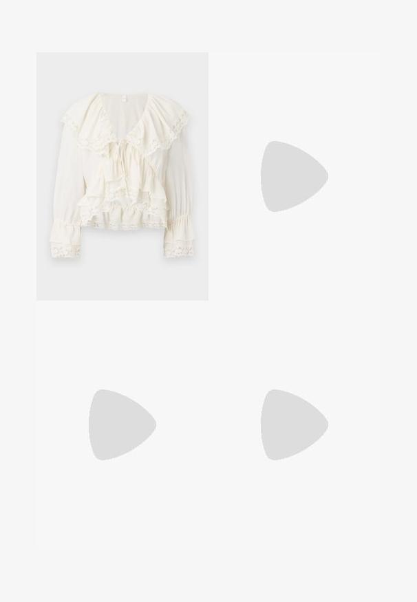 Witte blouse met een gelaagd, ruchesontwerp, kantafwerking op de mouwen en onderrand, en een V-halslijn met een trekkoordsluiting.; Donkerblauwe flared jeans van denim, met een hoge taille, vijf zakken en contrasterende stiksels langs de naden. Gladde textuur.; Beige Nike sneakers met bruine accenten, bovenwerk van suede en textiel, ronde neus, platte rubberen zool en vetersluiting.; Tortoiseshell zonnebril met rechthoekige bruine lenzen, een dik montuur en slanke armen met een patroon van variërende bruintinten.