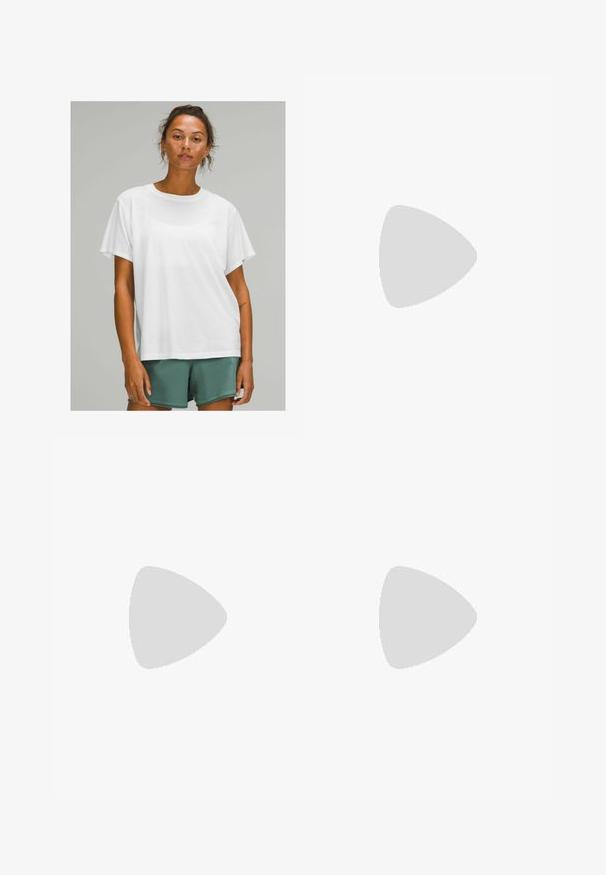 Bijela pamučna majica kratkih rukava, zaobljenog izreza, opuštenog kroja, nosi se s zelenim kratkim hlačama. Glatka tekstura, bez vidljivih uzoraka ili akcenata.; Lagane hlače boje senfa od sintetičkog materijala, s elastičnim pojasom i vezicom te sužavajućim nogavicama s detaljima od panela.; Bijela atletska obuća s teksturiranim mrežastim gornjim dijelom, reflektirajućim detaljima i podstavljenim potplatom. Značajan logo brenda sa strane.; Bijele sunčane naočale s smešnim lećama, ovalnog oblika, izrađene od glatke plastike, sivi detalji na ručkama i logotip na okviru.