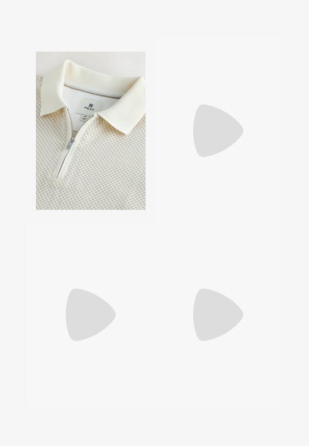 Kortærmet, lysefarvet zip-polo med struktureret krave og ternet mønster. Etiketten viser "NEXT", størrelse M, med sølvfarvet lynlåsdetalje.; Beige linned joggers med elastisk talje og justerbar snøre, med elastiske manchetter og en afslappet pasform. Glat tekstur.; Brun ruskind slip-on sko med rund tå, der har en vævet jute sål og et lille accentbånd over forfoden.; Guldmetal solbriller med runde, grøntonerede linser. De tynde stænger har klare plastspidser og viser et logo på linsen.