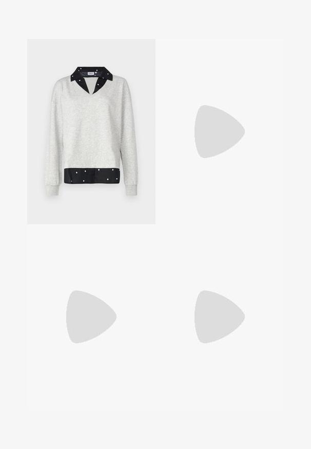 Szürke pulóver V-nyakkivágással és hosszú ujjakkal, fekete pöttyös szegéllyel és gallérral, puhából készült.; Világoskék farmernadrág, laza fit típussal, megviselt részletekkel, gombos záródással, két gombbal, és egyenes lábakkal.; Fehér bőr edzőcipő perforált orral, texturált talppal és fehér fűzővel, széles vörös nadrággal párosítva, kék és sárga háttérrel.; Arany fülbevalók sima, fényes felülettel. Kör alakú dizájn, amely kis kapoccsal és átlátszó tartozékkal rendelkezik a biztonságos viselés érdekében.