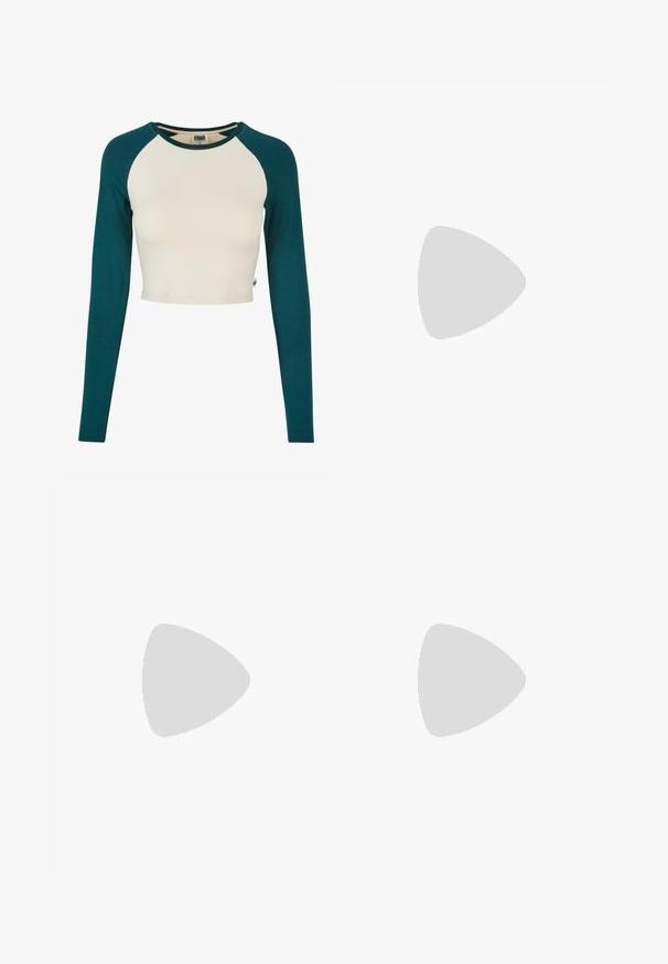 Top corto con mangas largas. Presenta un cuerpo de color crema y mangas en color verde azulado. Está hecho de algodón suave, con un escote redondo y detalles de costura mínimos.; Leggings amarillos neón con una cintura alta, textura suave y costuras curvadas; presentan un pequeño logo en la cintura. Combinados con zapatillas blancas.; Zapatilla blanca con materiales de malla y cuero, puntera redondeada, suela gruesa, cintas prominentes y logo en el talón y la lengüeta.; Gafas de sol cuadradas de carey con lentes marrones degradados, que cuentan con acentos dorados en las patillas y un marco grueso y brillante.