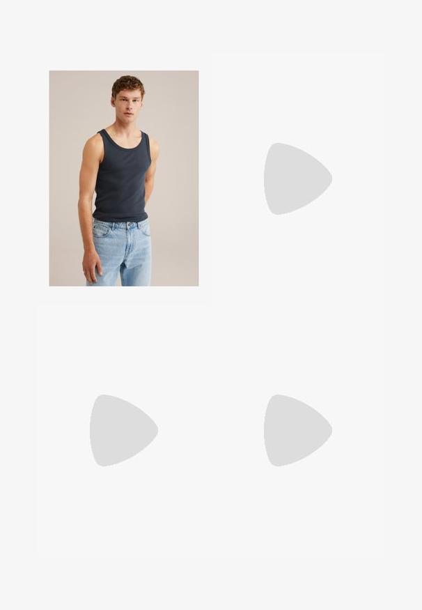 Ung mand med kort krøllet hår iført en marineblå ærmeløs trøje og lyseblå jeans foran en ensfarvet beige baggrund.; Sorte, løse bukser med elastisk talje og justerbar snor. Glat stof, lige ben-design og uden mønstre.; Gul gummichin med tekstureret sål, tynde stropper og multicolore striber langs sålen. Brandlogo på stropperne.; Wayfarer-solbriller med mørk skildpaddeplastikramme, grønne linser og sølvfarvet Ray-Ban-logo på stængerne.