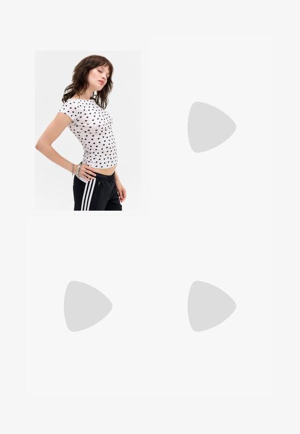 Hvid kortærmet t-shirt med navy polka dots, tætsiddende design, rund udskæring og diskrete sidesømme. Bæres med sorte træningsbukser.; Lyseblå sweats med lilla sidestreger, elastisk talje og lynlåslommer. Blødt stof og lige ben-design.; Sorte læder støvler til knæene med en glat struktur, smygende design, spids tå og en lav firkantet hæl. Minimalistisk stil uden synligt hardware.; Metalisk sølvhandtaske med en struktureret form, to topstropper og lynlåslommer på forsiden. Glat, blank overflade.