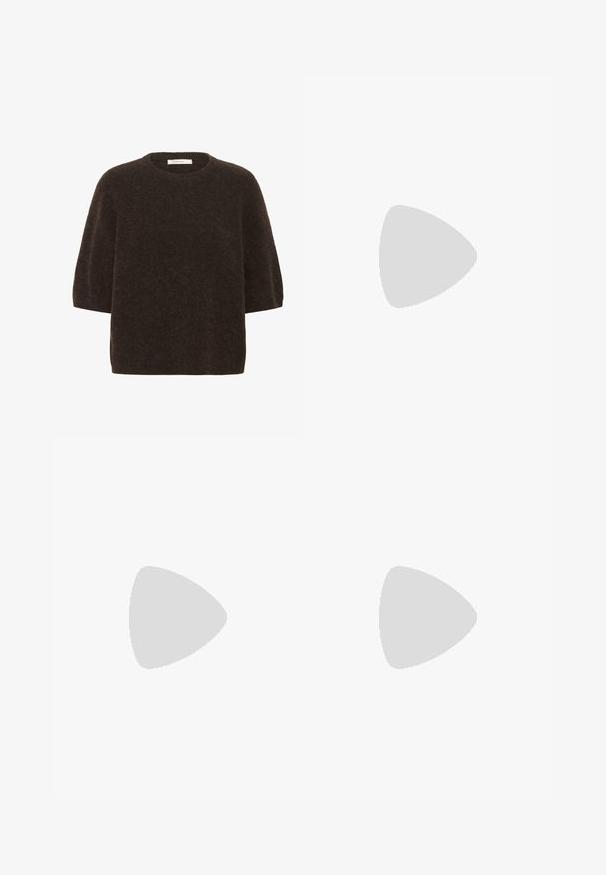 Mörkbrun ulltröja med rundad halsringning, korta ärmar och en avslappnad passform. Texturerad yta med en något fuzzy utseende.; Svarta vida jeans i denim. Har hög midja, två framfickor och metallknäppning. Texturerad yta med minimal blekning.; MCM SKYWANDER - Stövel - black; Kvinna med håret i knut sitter på sidan av en ljusbrun läderstol, håller en tan-mönstrad tote-väska med svarta logotyper och en gyllene emblem.