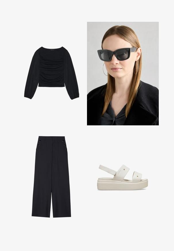 Zwarte longsleeve top met geplooid stofdetail aan de voorkant en bij de polsen, gemaakt van zachte, rekbare stof met een barco neckline.; Zwarte wijde broek in donkerblauw materiaal, met een gladde textuur, voorplooien en decoratieve goudkleurige ogen op de zijzakken.; Witte platform sandalen met brede banden, gemaakt van glad materiaal, met een verstelbare achterband en een uitgesproken zool. Minimalistisch ontwerp.; Zwarte cat-eye zonnebril met donkere lenzen, dikke monturen en subtiele accenten. Draagt een zwarte jas en een grijze top, met lang stijl haar.