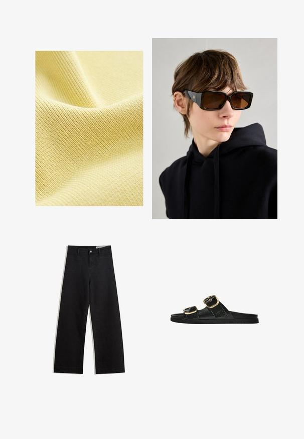 Tessuto giallo strutturato con un fine motivo a coste, superficie liscia e un aspetto morbido e leggero. Ideale per abbigliamento o tappezzeria.; Pantaloni in denim neri a gamba larga con vita alta, dotati di tasche anteriori e posteriori, cuciture a punto, e chiusura con bottone. Texture liscia.; Infradito neri con due accenti di fibbia dorata, materiale dalla texture liscia, suola piatta e design minimalista.; Occhiali da sole neri oversize con finitura lucida, forma rettangolare, lenti marroni e dettagli del logo dorato sulle astine.