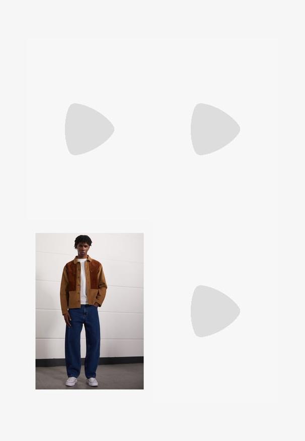 Oakley STACKED TEE - T-shirts med print - mist; Mann som står innendørs iført en brun kordfløyelsjakke med rustfargede flekker, hvit t-skjorte, løse blå jeans og hvite sneakers.; Grå og svart Nike løpesko med synlig fjærlignende demping under sålen og en hvit swoosh-logo på siden.; Svart skulderveske laget av teksturert stoff, med skrådesign, justerbar stropp og snøring på sidene.