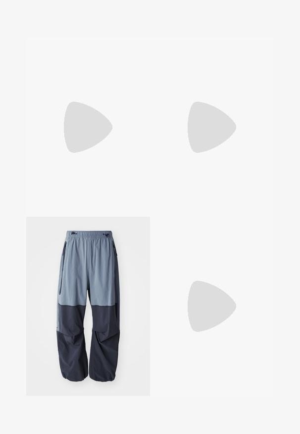 T-shirt beige a maniche corte in cotone, con la scritta nera "USO UFFICIALE SOLO" e logo Nike sul lato sinistro del petto.; Pantaloni outdoor larghi bicolore con una parte superiore azzurro chiaro e una parte inferiore blu navy, dotati di vita con coulisse e tasche laterali.; Scarpe sportive nere con dettagli blu e argentati, caratterizzate da una tomaia testurizzata, un design audace della suola e un sistema di allacciatura. Posizionate su un tappeto blu.; Occhiali da sole neri avvolgenti con lenti verde scuro. Finitura opaca, design curvo, con aste dritte e un branding sottile sul lato.
