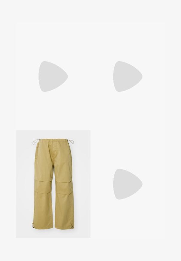 Polo negro hecho de algodón, con un cuello suave, mangas cortas y un diseño de escote en V sin patrones o acentos adicionales.; Pantalones cargo en color caqui, con piernas anchas, cintura elástica, bolsillos frontales y puños ajustables con cordón. Fabricados con tejido ligero.; Zapatillas de ante y malla amarillas con acentos a rayas en negro y blanco, suelas texturizadas y diseño con cordones. Medias blancas visibles por encima del tobillo.; Collar de cadena de metal plateado que presenta eslabones gruesos entrelazados, textura pulida y un pequeño broche con detalles de marca.