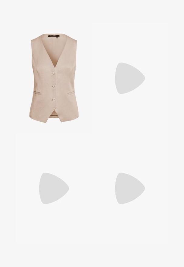 Beige ärmellose Weste aus einem Leinenmix, mit tiefem V-Ausschnitt, fünf Knöpfen und zwei Seitentaschen. Klassische gerade Form mit subtiler Textur.; Weißes ärmelloses Top mit tiefem V-Ausschnitt, aus einem weichen, glatten Stoff gefertigt. Gerade Saum und minimale Details.; Hellblaue Jeans aus Denim mit geradem Bein, fünf Taschen und einem mittelhohen Bund. Sie verfügen über eine ausgewaschene Textur und einen gesteppten Saum.; Braune Wildleder-Sneaker mit weißen Akzenten und Schnürsenkeln. Gummisohle in Kautschuk-Optik. Getragen mit weißen Socken, die schwarze Streifen haben. Grüner strukturierter Fußboden.