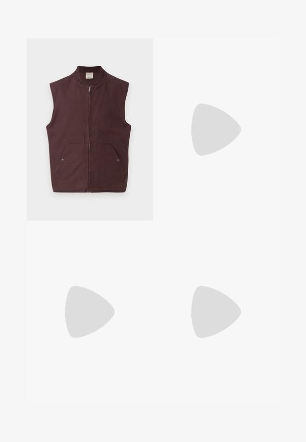 Chaleco sin mangas de color marrón oscuro con cremallera, cuello acanalado y dos bolsillos frontales asegurados con botones a presión, mostrado sobre un fondo blanco.; Camiseta blanca de algodón con escote redondo y mangas cortas, con un logo dorado de EA7 Emporio Armani impreso en el frente.; Pantalones cortos deportivos negros de tejido suave, con una cintura elástica y un pequeño logo amarillo de EA7 en la parte inferior de la pierna izquierda.; Zapatilla de cuero blanca con un acabado suave, puntera redonda, cordones planos y suela texturizada. Cuenta con un sutil logo en el talón.
