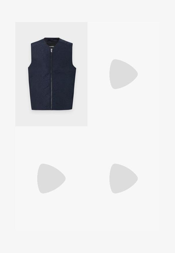 Marinblå väst med intrikata geometriska mönster, med hög krage och dragkedja fram. Tillverkad av ett texturerat tyg, lätt och ärmlös.; Vit kortärmad t-shirt, lös passform, rund halsringning, mjukt bomullstyg, enkel baksida, rak nederkant, utan mönster eller detaljer.; Svarta joggingsbyxor i mjukt material, med dragsko i midjan, löst snitt och raka ben. Minimalistisk stil utan mönster.; Svart läder Chelsea-boots med elastisk sidopanel, rund tå, dragflik bak, och en låg staplad klack. Slät, polerad yta.