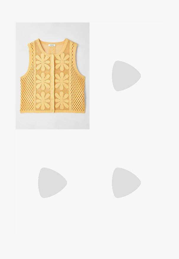 sandro Smanicato - jaune; Due top in maglia senza maniche, a collo alto, in nero e bianco, con un design aderente e una superficie liscia, di lunghezza cropped.; Pantaloni neri a gamba larga realizzati in tessuto leggero, caratterizzati da una chiusura frontale con bottone e frontale piatto, con orli cuciti con precisione.; Scarpe sportive con tomaia in pelle bianca, punta in suede grigia e tre strisce nere. Presentano un logo blu sulla linguetta e una suola in gomma testurizzata.